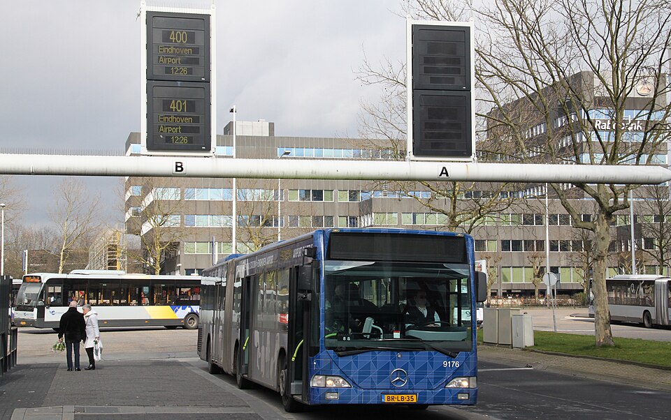 An airport shuttle bus parked at the curb