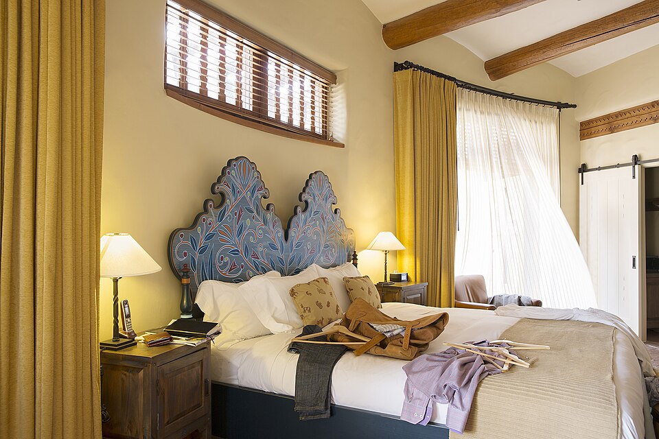 A hotel room with a double bed and warm light