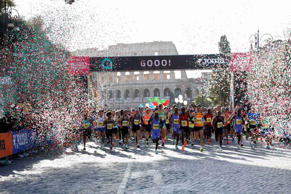 Largada da Maratona de Roma diante do Coliseu, com confete nas cores da bandeira italiana