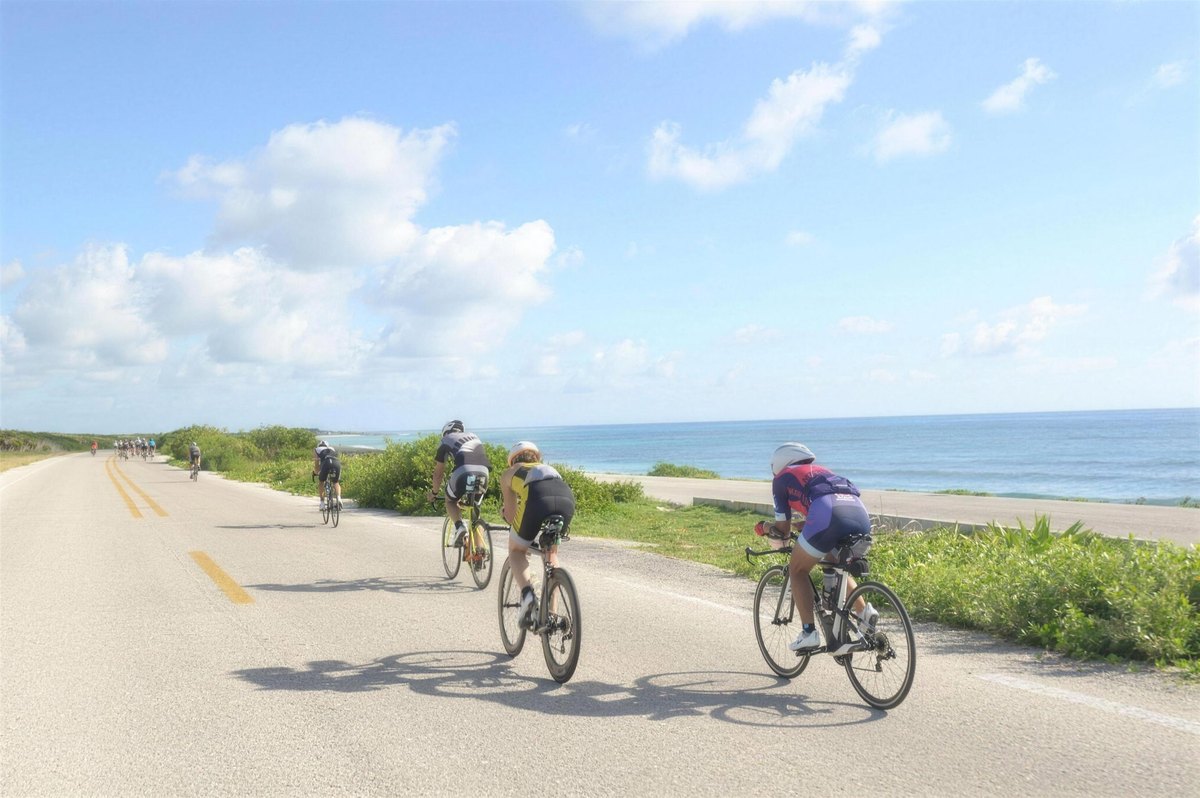 Triathletes riding the coastal bike course along the Cozumel shoreline