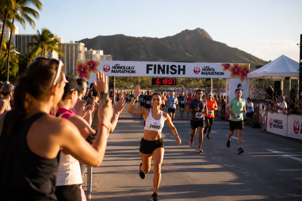 Runner celebrando la meta en ambiente tropical