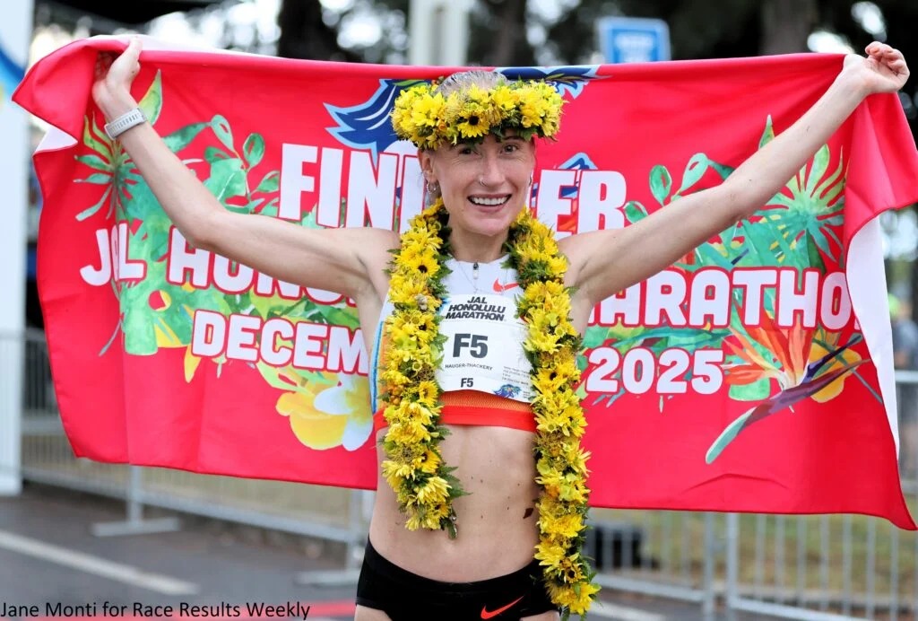 Runner celebrating with a flower lei at the Honolulu Marathon finish line. Photo by Jane Monti for Race Results Weekly