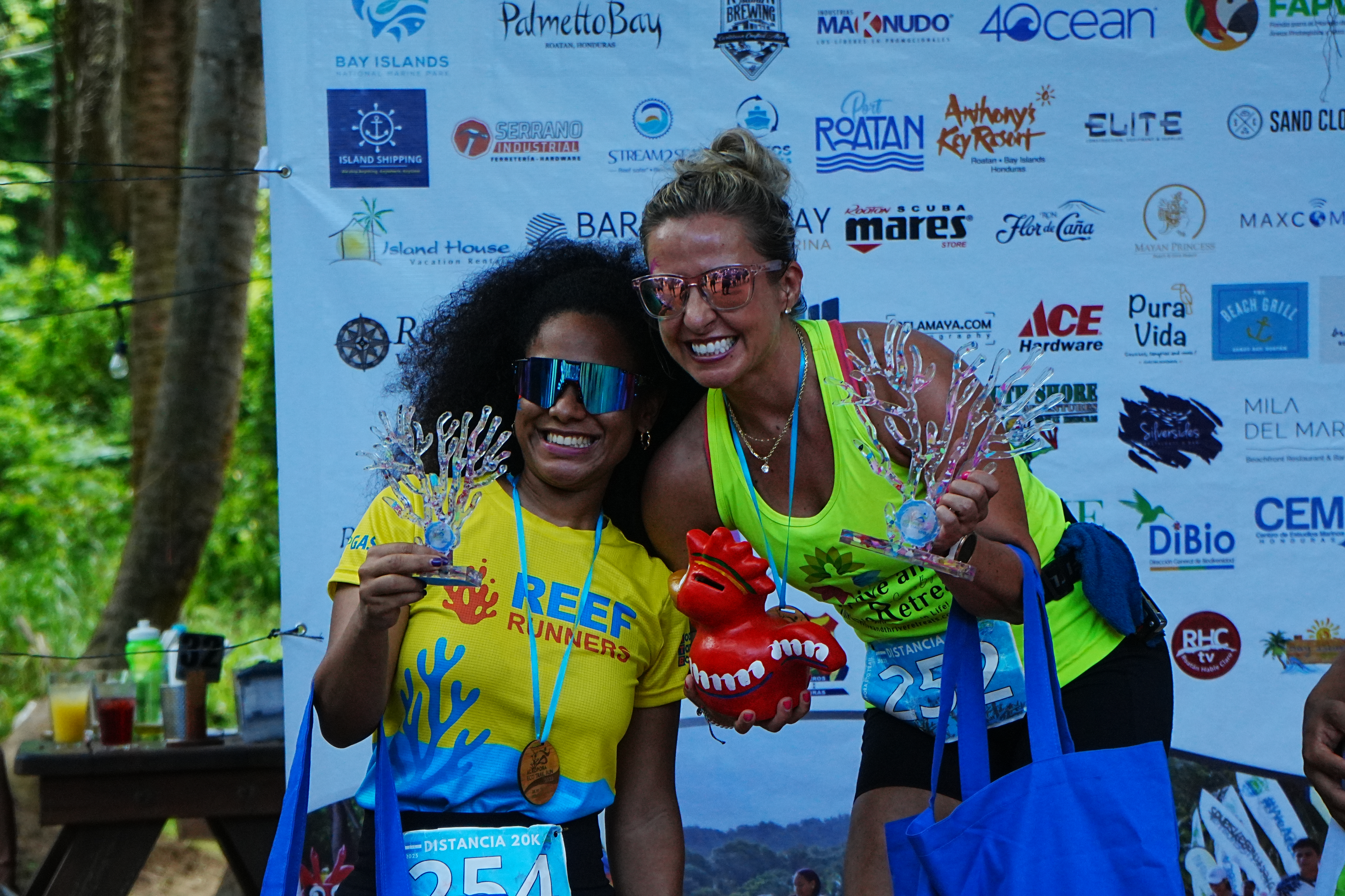 Runner cruzando la meta y logística de carrera en Roatán